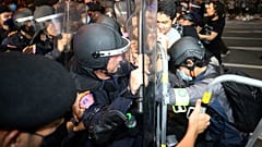 Pro-democracy protesters push Thai policemen with riot shields during a demonstration in Bangkok, Thailand, Thursday, Oct. 15, 2020. 