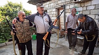 سكان محليون يحملون بنادق كلاشينكوف تلقوها من مكتب التجنيد في بلدة مارتوني، الأربعاء 14 أكتوبر 2020