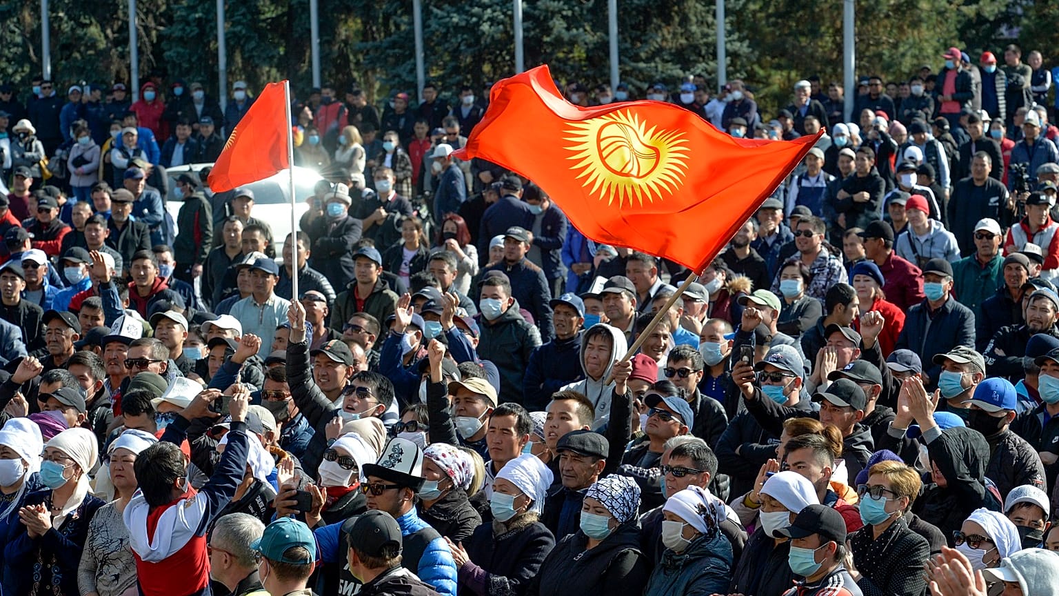 Protesters react waving Kyrgyz national flags as they wait in front of the government building in Bishkek, Kyrgyzstan.