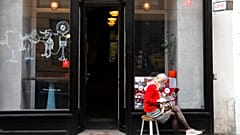 A woman sits in front of a cafe in Prague