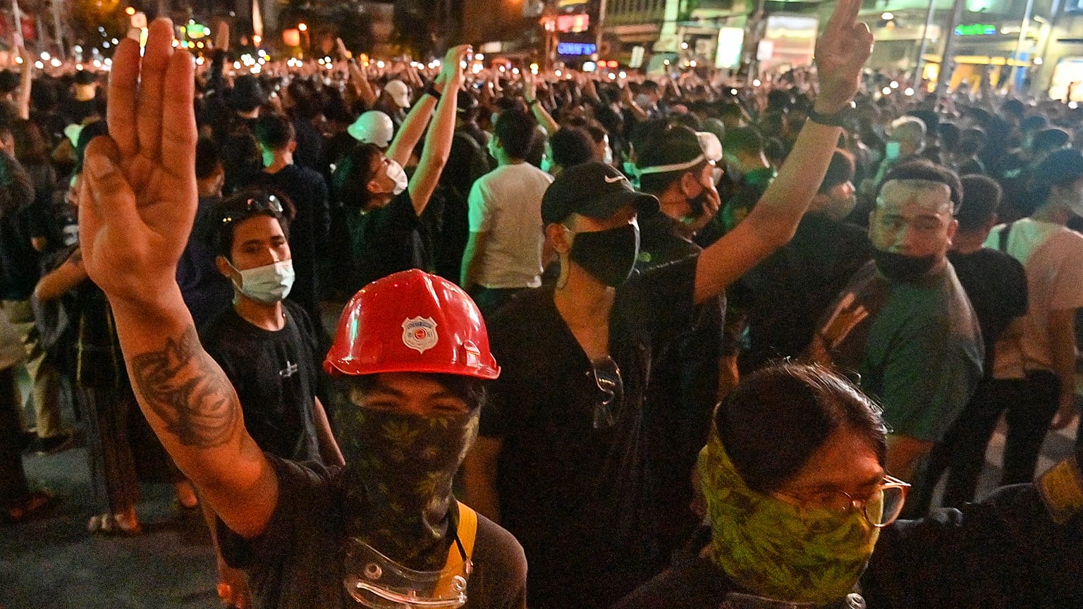 Pro-democracy protesters give the three-finger salute during an anti-government rally at Asok in Bangkok on October 18, 2020