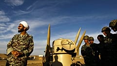  In this Nov. 13, 2012 file photo, an Iranian clergyman stands next to missiles and army troops, during a manoeuvre, in an undisclosed location in Iran.