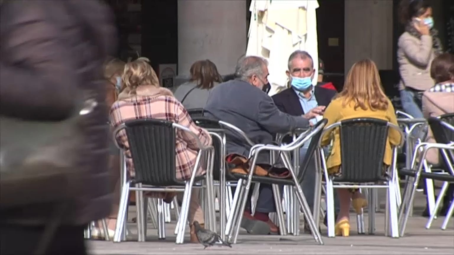 Clientes con mascarillas en una terraza 