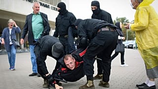 Rendőrök őrizetbe vesznek egy tiltakozót az elnökválasztás eredménye elleni tüntetésen Minszkben szeptember 27-én.