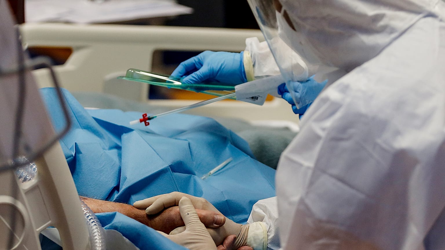 Une infirmière tient la main d'un patient atteint du Covid-19 dans l'unité de soins intensifs de l'hôpital Casal Palocco à Rome Mardi 20 octobre 2020