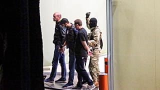 A gunman could be seen escorting three individuals out of the bank building on Wednesday.