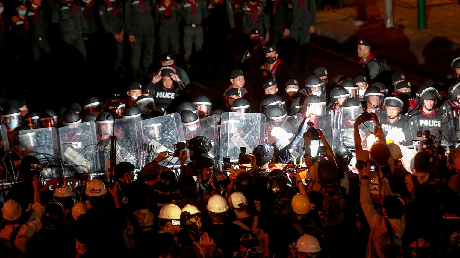 Pro-democracy activists confront a police blockage during their march to the Government House, prime minister's office during a protest march in Bangkok, Thailand, Wednesday, 