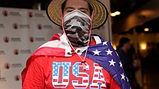 Un joven latino asiste envuelto en una bandera estadounidense a uno de los debates de "Latinos for Trump"
