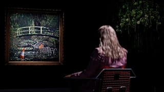 Eine Londoner Sotheby` s `Mitarbeiterin scheint im jetzt versteigerten Banky-Werk förmlich zu versinken 