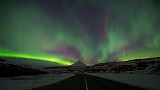 Northern Lights, or aurora borealis, appear in the sky over Bifrost, Western Iceland.