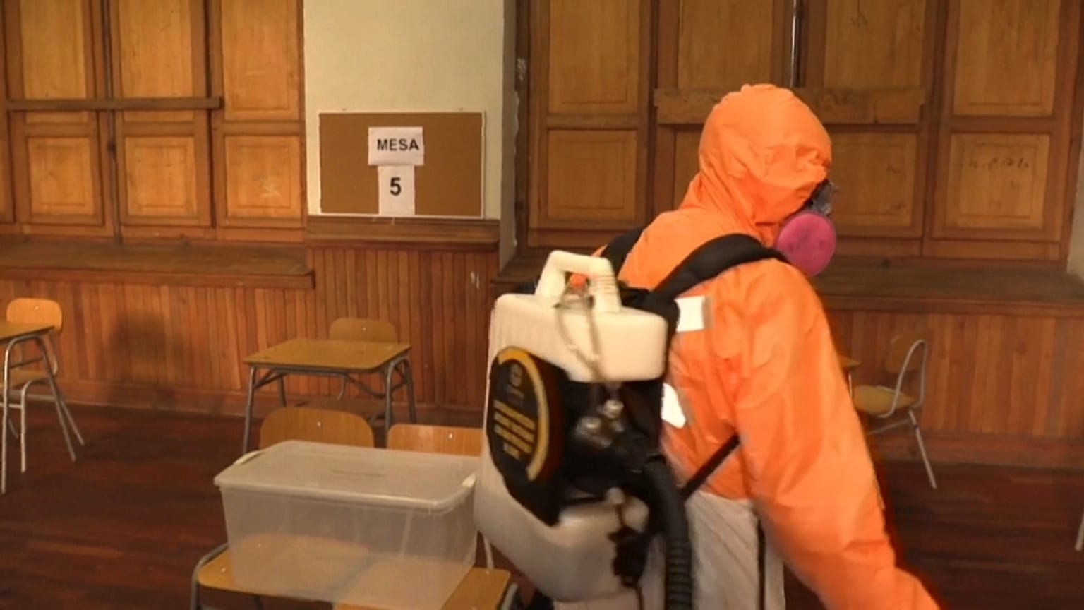 Un trabajador desinfectando un centro de votación en Santiago 