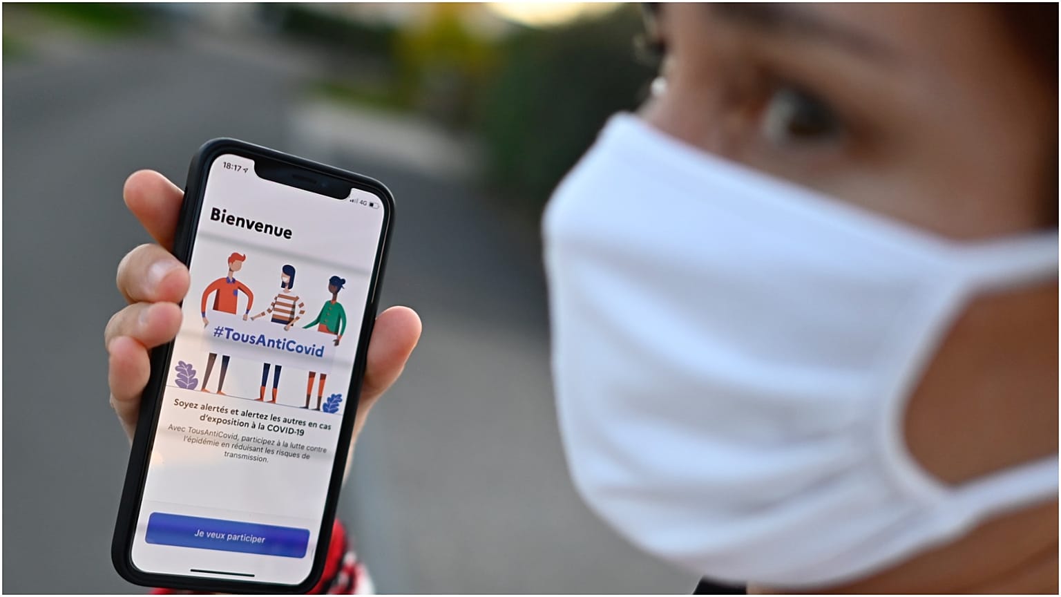 سيدة تظهر تطبيقا لتتبع حالات كورونا