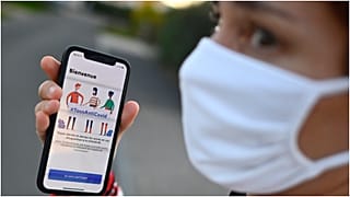 سيدة تظهر تطبيقا لتتبع حالات كورونا