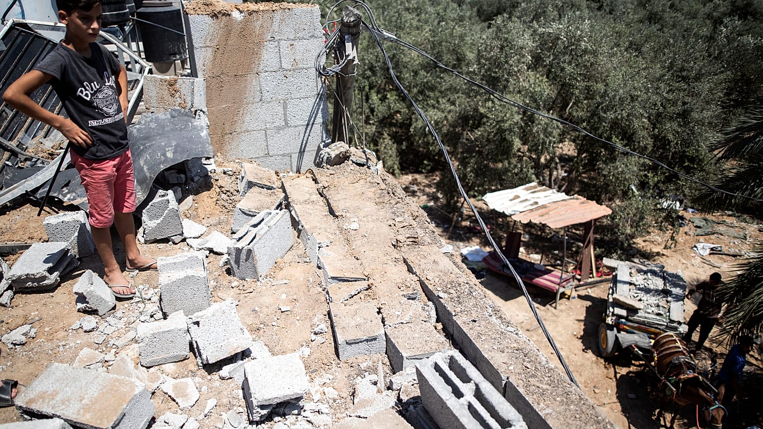 طفل فلسطيني يتفقد أضرارا لحقت بمنزل عائلته إثر غارة جوية إسرائيلية على مخيم البريج في قطاع غزة. أرشف - 2020/08/15