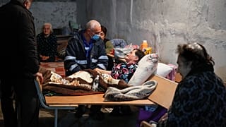 موظف في مجال الصحة يتحدث لعجوز في ملجإ في ستيبانكرت إحدى مناطق ناغورنو قره باغ. 2020/10/22