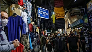 University students wearing face masks to curb the coronavirus protest as they walk in Monastiraki flea market in Athens