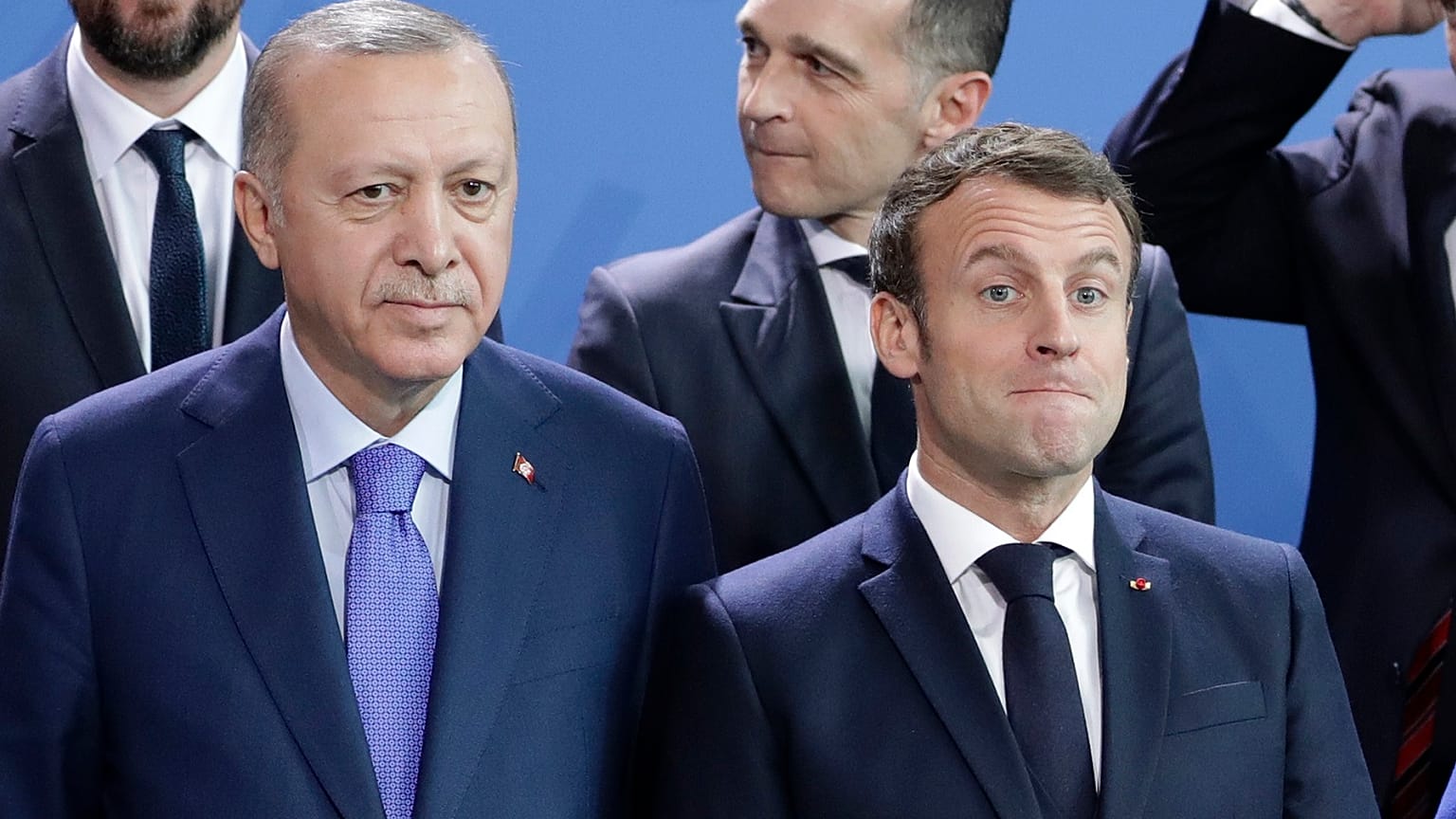 Turkey's President Recep Tayyip Erdogan, left and French President Emmanuel Macron stand, during a group photo at a conference on Libya in Berlin.