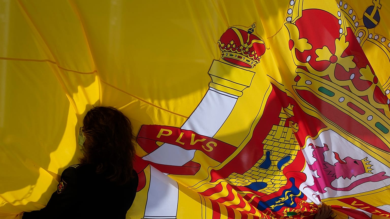 A woman holds a Spanish flag during a memorial for coronavirus victims in Madrid, Spain, Friday, October 23, 2020.