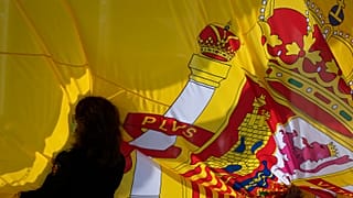 A woman holds a Spanish flag during a memorial for coronavirus victims in Madrid, Spain, Friday, October 23, 2020.