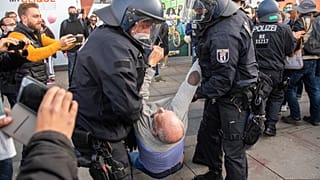 Polizisten tragen Teilnehmer einer Anti-Corona-Demonstration auf dem Alexanderplatz weg, 25.10.2020