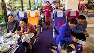 A flight attendant serves welcome drinks in a flight-themed restaurant at the Thai Airways head office in Bangkok