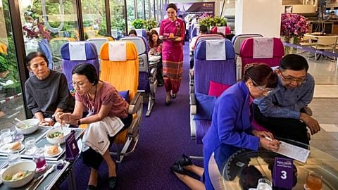 A flight attendant serves welcome drinks in a flight-themed restaurant at the Thai Airways head office in Bangkok