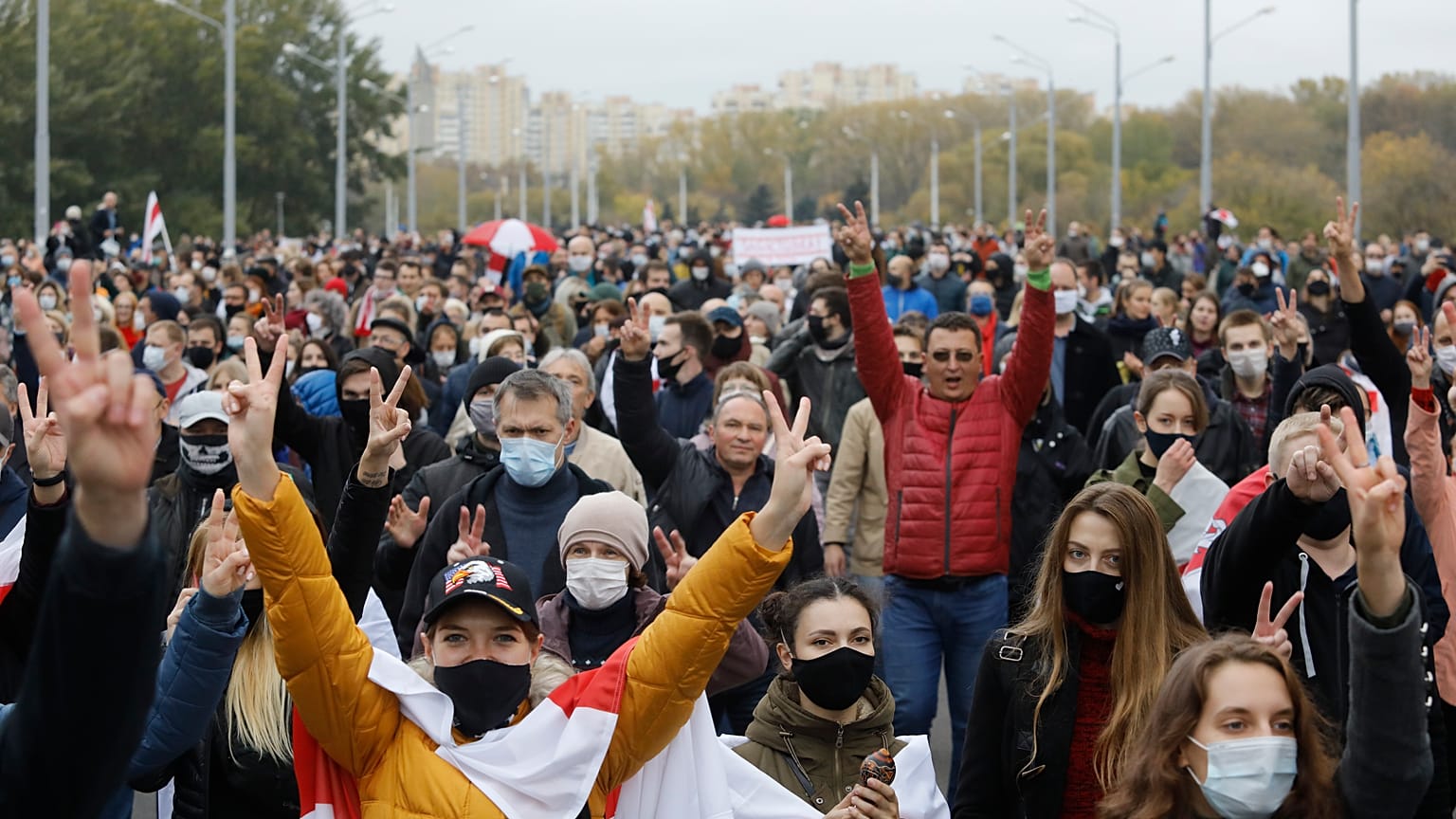 People with old Belarusian national flags march during an opposition rally to protest the official presidential election results in Minsk, Belarus, Sunday, Oct. 25, 2020