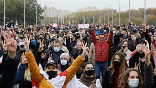 People with old Belarusian national flags march during an opposition rally to protest the official presidential election results in Minsk, Belarus, Sunday, Oct. 25, 2020