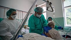 Védőfelszerelést viselő orvos megvizsgál egy beteget a Szent János Kórházban 2020. május 14-én
