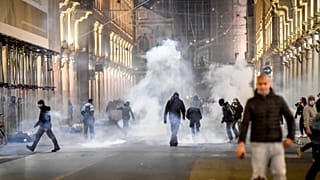 Smoke billows as clashes broke out during a protest against the government restriction measures to curb the spread of COVID-19 in Turin, Italy, Monday, Oct. 26, 2020.
