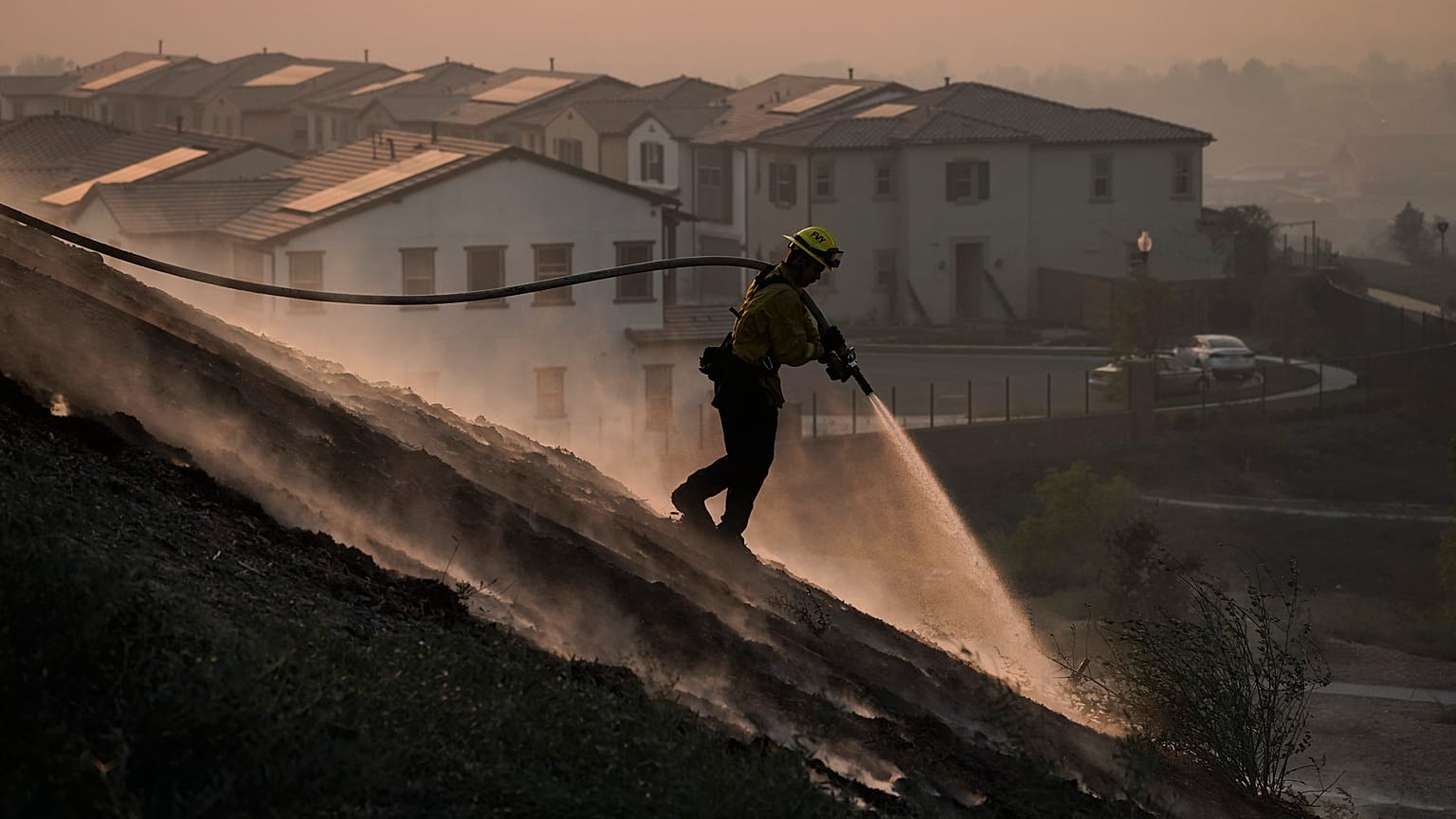 Firefighter Tylor Gilbert puts out hotspots while battling the Silverado Fire, Monday, Oct. 26, 2020, in Irvine, California, USA.