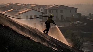 Firefighter Tylor Gilbert puts out hotspots while battling the Silverado Fire, Monday, Oct. 26, 2020, in Irvine, California, USA.
