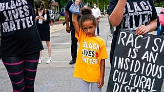 Six-year-old Deja holds her hand in the air during a Black Lives Matter protest Tuesday, Sept. 1, 2020, in Kenosha, Wis.