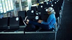 A passenger, wearing a face mask to protect against the spread of coronavirus, sits before boarding her flight at the Zaventem international airport