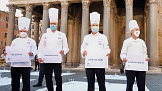 Cozinheiros em protesto em frente ao panteão de Roma com as mensagem "#cozinheiros", "#estamos por terra", "#restaurantes" e "#inovação"