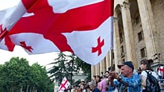 Opposition demonstrators wave a Georgian national flags as they gather in front of the Georgian Parliament building in Tbilisi, Georgia, Monday, June 24, 2019.
