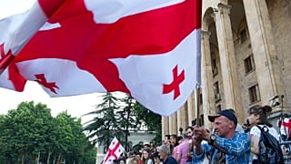 Opposition demonstrators wave a Georgian national flags as they gather in front of the Georgian Parliament building in Tbilisi, Georgia, Monday, June 24, 2019.