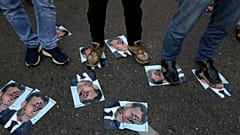 Demonstrators stand on defaced images of French President Emmanuel Macron during a protest in Karachi, Pakistan, against the publishing of caricatures of the Prophet Muhammad.