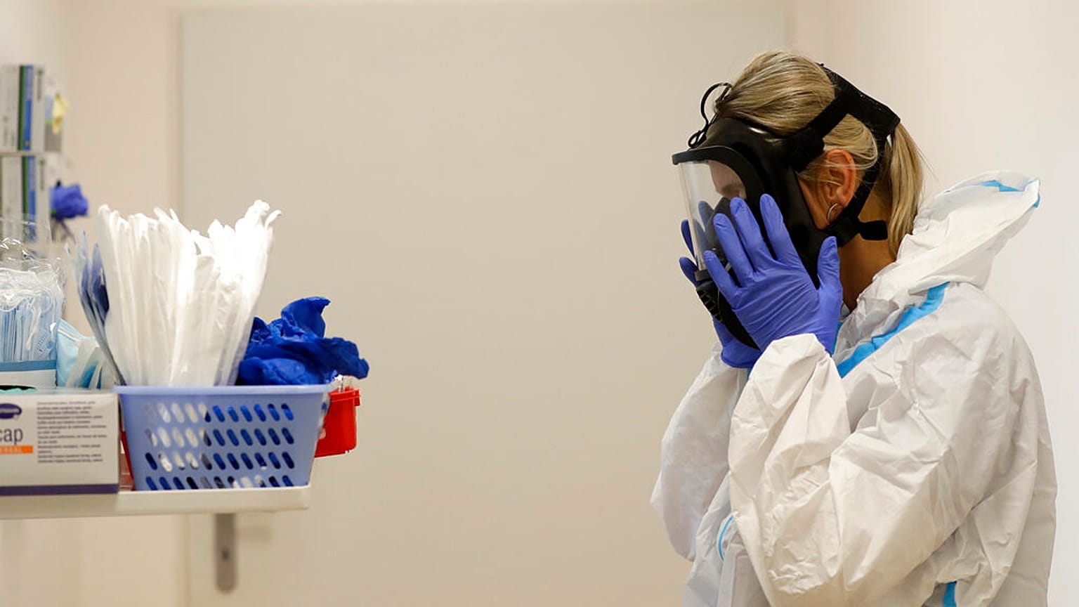 A health care worker puts on personal protective equipment (PPE) before tending to COVID-19 patients at an intensive care unit (ICU) at a hospital in Kyjov, Czech Republic.