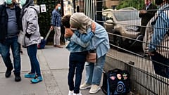 A woman, wearing a face mask to fight against the spread of the coronavirus, hugs her child before entering the Heembeek primary school during the first day of classes in Brus
