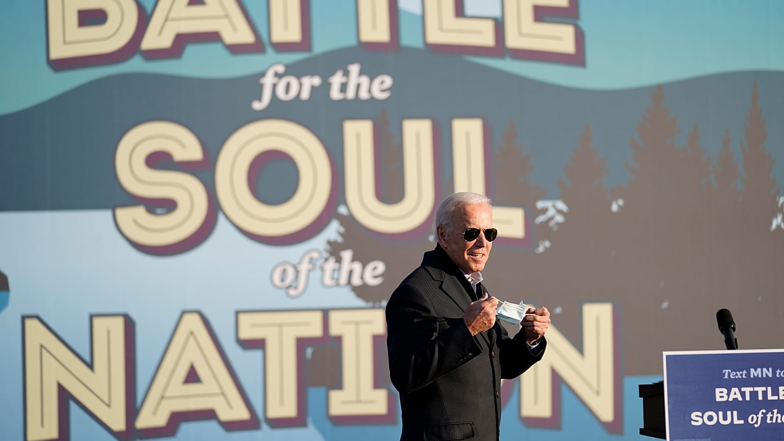 Democratic presidential candidate former Vice President Joe Biden holds his face mask during a rally at the Minnesota State Fairgrounds in St. Paul, Minn., Friday, Oct. 30, 20