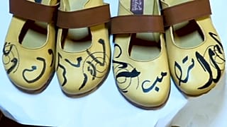 أحذية مصنوعة يدويا مكتوب عليها اسمي ترامب وماكرون