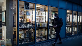 A masked man walks by a bookstore in Paris, Thursday October 29, 2020.