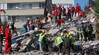 Members of rescue services search for survivors in the debris of a collapsed building in Izmir, Turkey, Saturday, Oct. 31, 2020