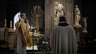 Priest Henri de La Hougue, left, celebrates the All Saints Day mass in Saint-Sulpice church, in Paris, Sunday, Nov. 1, 2020.