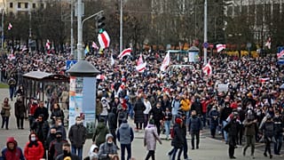 Demonstrators with old Belarusian national flags march during an opposition rally to protest the official presidential election results in Minsk, Belarus, Sunday, Nov. 1, 2020