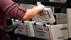 FILE - An election worker sorts vote-by-mail ballots at the Miami-Dade County Board of Elections in Doral, Fla., on Oct, 26, 2020. 