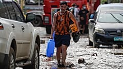 Filipinlerin Batangas eyaletinde, Goni Tayfunun neden olduğu sel sularının ardından çamurla kaplı bir yolda yürüyen köy sakini