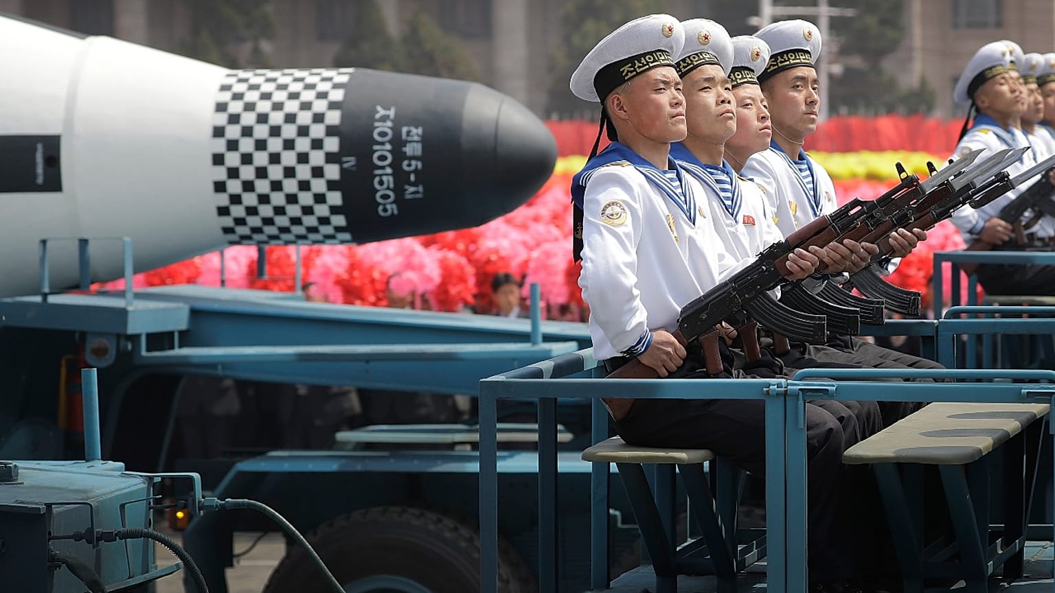 Kuzey Kore Donanma'ına bağlı personel, askeri geçit töreninde denizaltından fırlatılan "Pukguksong" balistik füzesinin (SLBM) önünde otururken