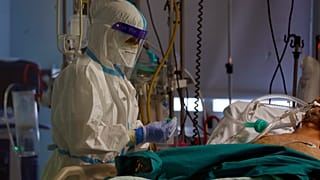 A medical staff tends to a patient inside the COVID-19 intensive care unit at the San Filippo Neri hospital in Rome, Tuesday, Nov. 3, 2020.